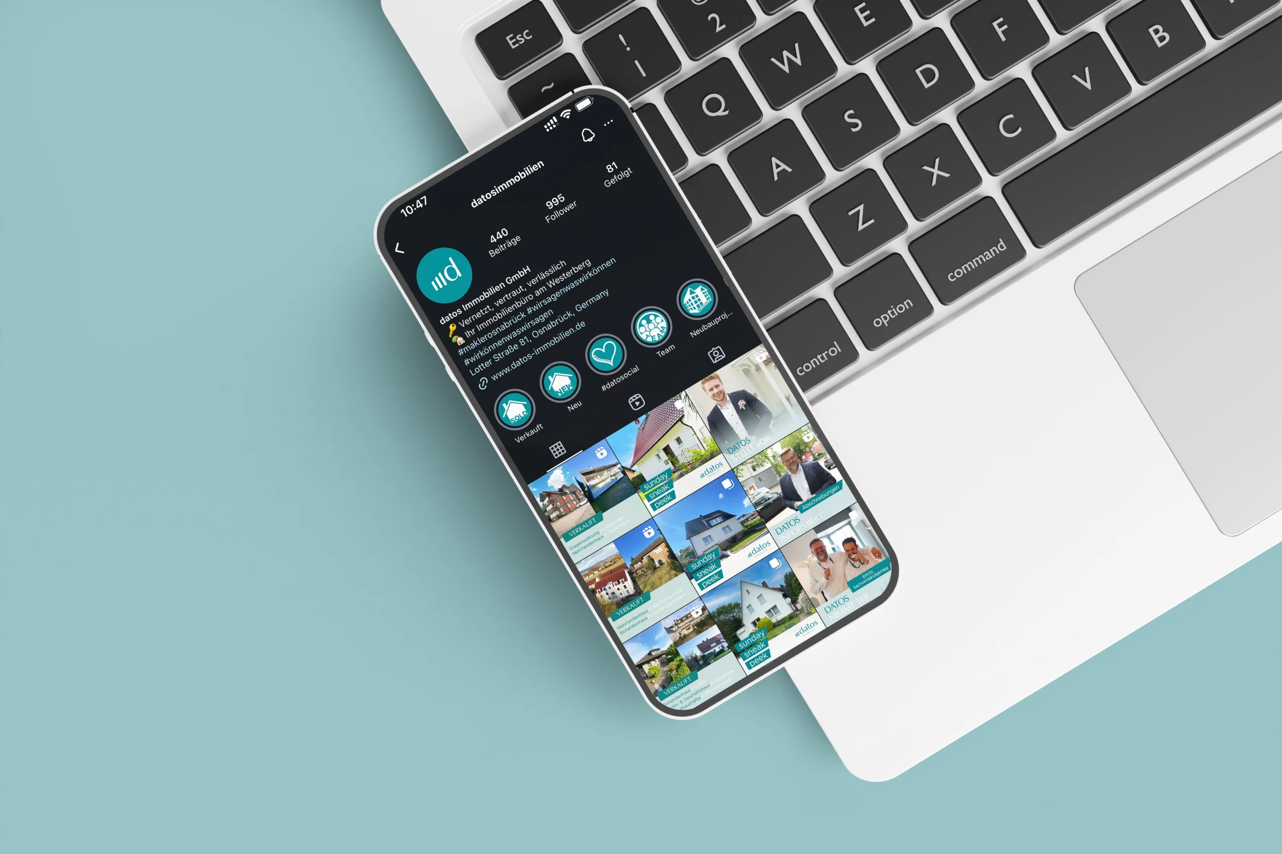 Ein Smartphone zeigt eine Instagram-Seite eines Immobilienunternehmens, liegt auf einer Laptop-Tastatur.