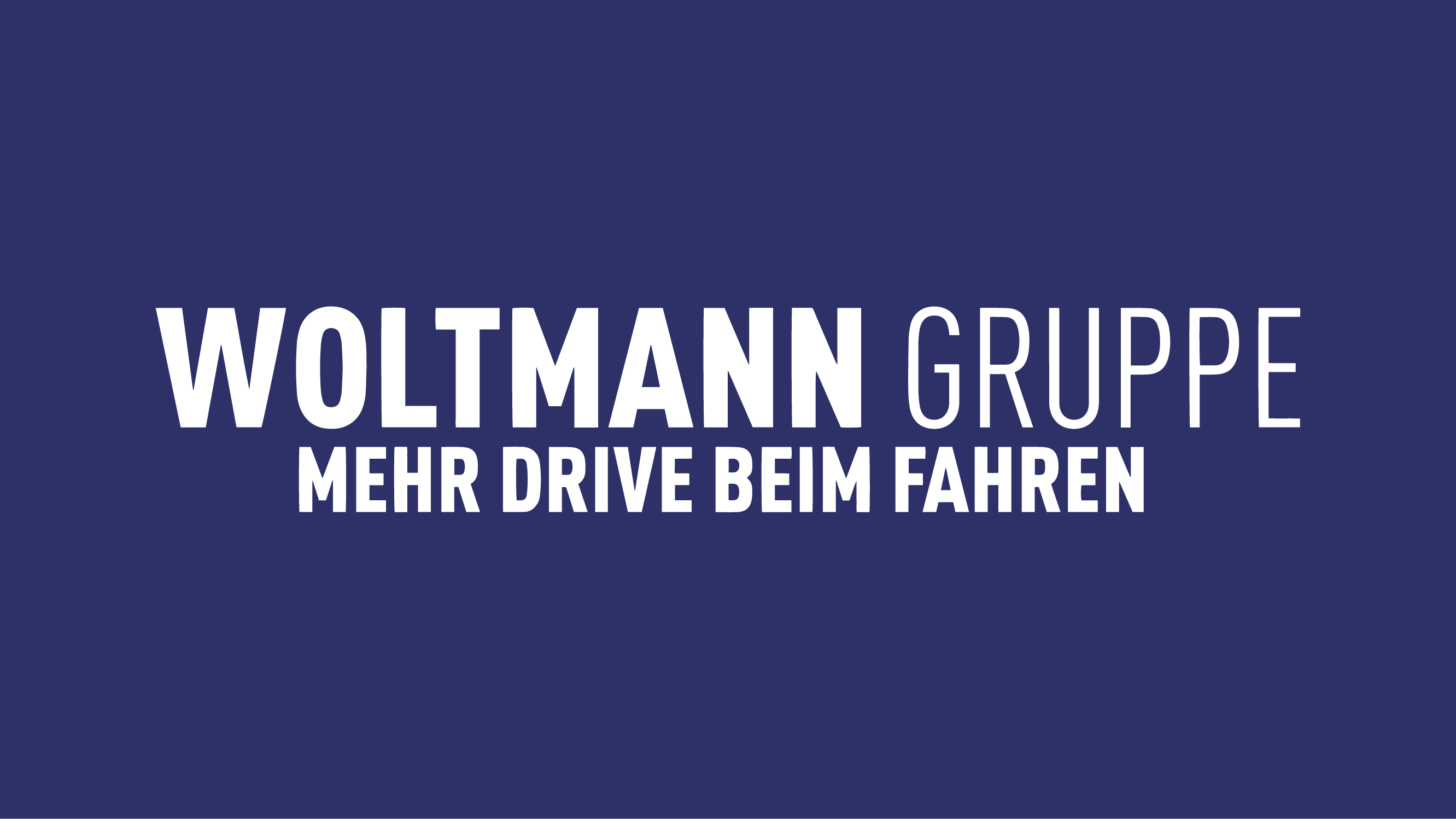 Logo der Woltmann Gruppe mit dem Slogan "MEHR DRIVE BEIM FAHREN" auf dunkelblauem Hintergrund.