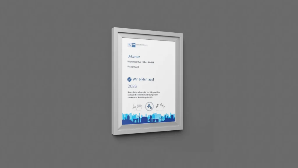 Gerahmte Urkunde an grauer Wand, die die "Digitalagentur Hölker GmbH" als IHK-geprüften Ausbildungsbetrieb auszeichnet.
