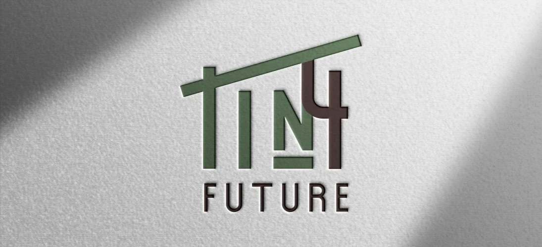 Logo mit dem Text "TINY FUTURE", stilisiert als Hausdach, in Grüntönen und Braun auf hellgrauem Hintergrund.