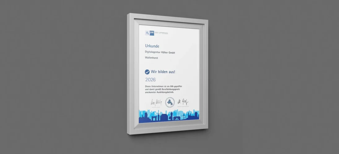 Gerahmte Urkunde an grauer Wand, die die "Digitalagentur Hölker GmbH" als IHK-geprüften Ausbildungsbetrieb auszeichnet.